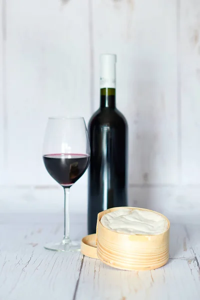 Garrafa e copo de vinho tinto e queijo — Fotografia de Stock