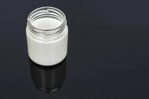 Yogur de leche de cabra en frasco de vidrio sobre fondo negro - horizontal — Foto de Stock