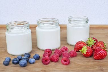 Üç kavanoz yoğurt ve çilek varyasyonu ile cam