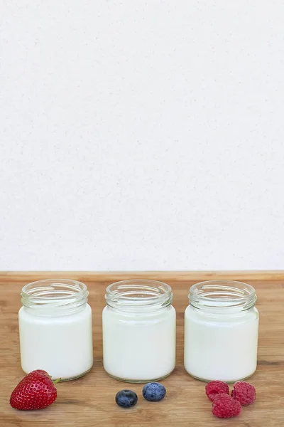 Tiga toples kaca dengan yogurt dan variasi buah beri - buah yang dihitung — Stok Foto