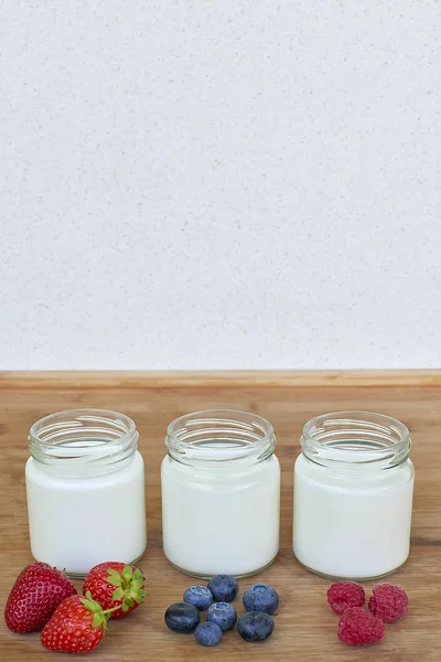 Tiga toples kaca dengan yogurt dan variasi buah beri - vertikal — Stok Foto