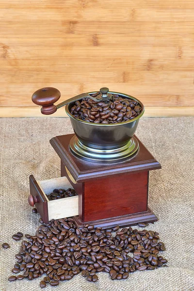 Kahve değirmeni kavrulmuş kahve çekirdekleri - ahşap arka plan tam