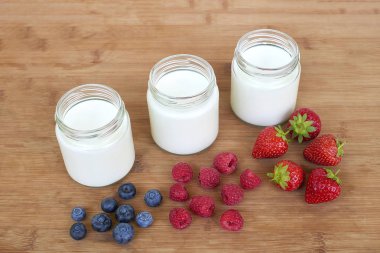 Üç kavanoz yoğurt ve meyveler - varyasyonu ile hemen üstüne cam