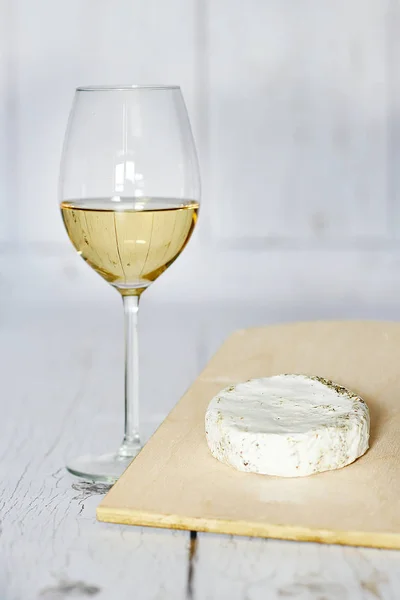 Copo de vinho branco e queijo camembert sobre um fundo de madeira — Fotografia de Stock