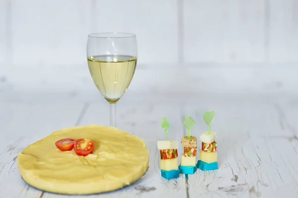Copa de vino blanco, polenta con tomate cherry y canapés de queso sobre fondo de madera — Foto de Stock