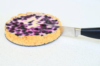 Beyaz bir arka plan üzerinde bıçak kesim böğürtlenli turta 