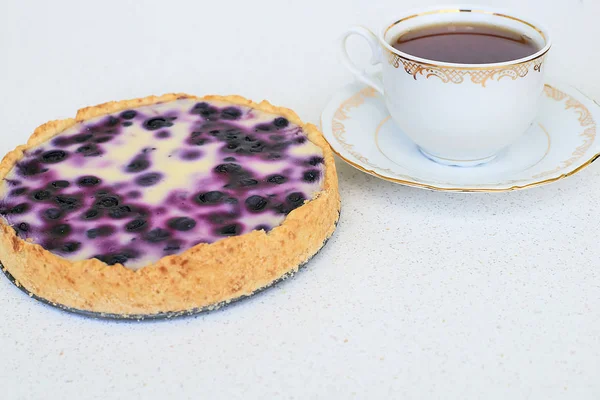 Fincan çay ve yaban mersinli pasta beyaz bir arka planda - yatay