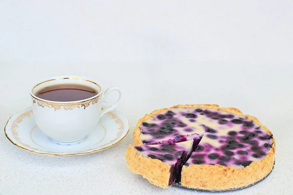 Taza de té y pastel de arándanos sobre un fondo blanco — Foto de Stock