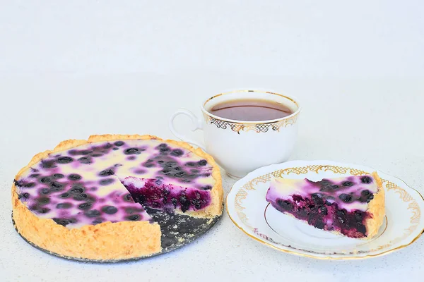 Taza de té y pastel de arándanos sobre un fondo blanco — Foto de Stock