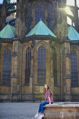 Ekose desenli gömlek genç kız çeşme Prag'da church yakınındaki oturuyor