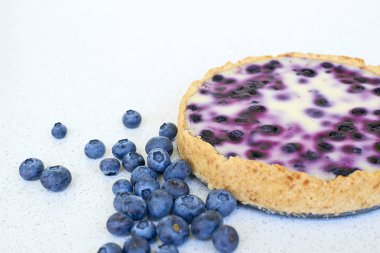 Yaban mersinli pasta ve yığın yaban mersini beyaz bir arka planda - sağ tarafta pişmiş