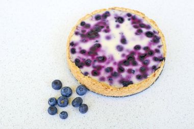 Yaban mersini pişmiş pasta ve yığın yaban mersini beyaz bir arka planda - yüksek açılı görünüş