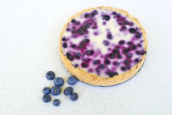 Yaban mersini pişmiş pasta ve yığın yaban mersini beyaz bir arka planda - yüksek açılı görünüş