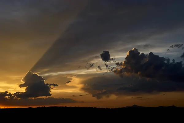 Bunter dramatischer Himmel mit Wolken und Sonnenstrahlen bei Sonnenuntergang — Stockfoto
