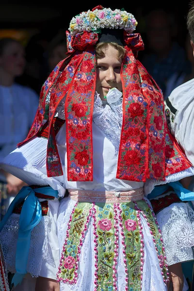 10-12 let chlapec, který byl vybrán jako král na jízdu králů folklórní festival. On je oblečený v ženské šaty a drží bílé růže květ v ústech — Stock fotografie