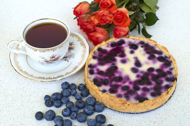 Böğürtlenli turta, fincan çay, yaban mersini ve kırmızı gül beyaz bir arka planda - hogh görüş açısı yığını