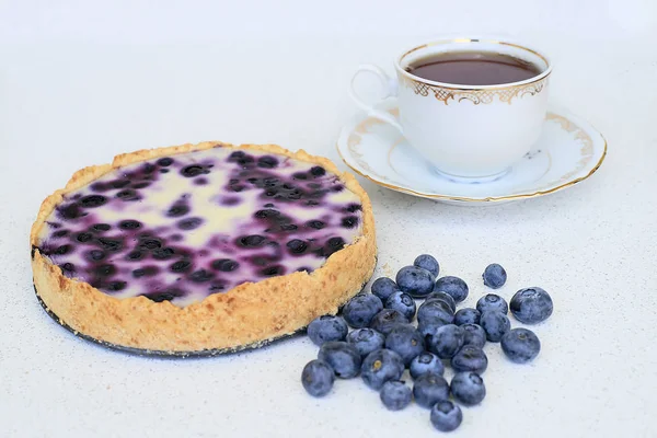 Böğürtlenli turta, fincan çay ve beyaz bir arka planda - yaban mersini yığını kapat