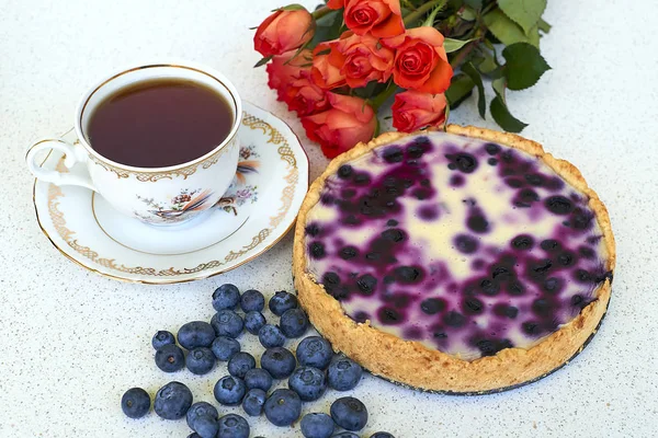 Böğürtlenli turta, fincan çay, yaban mersini ve kırmızı gül beyaz bir arka planda - hogh görüş açısı yığını