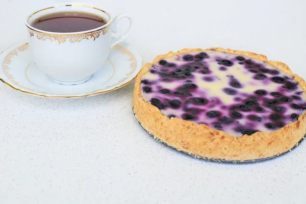 Böğürtlenli turta ve siyah çay beyaz bir arka planda - natürmort gıda