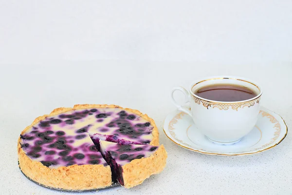 Tarta de arándanos y taza de té negro caliente sobre un fondo blanco - maqueta de plantilla — Foto de Stock