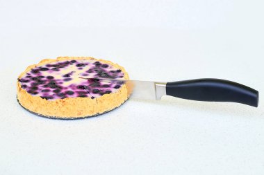 Böğürtlenli turta mutfak bıçağı tarafından beyaz bir arka plan üzerinde kesme - yakın çekim