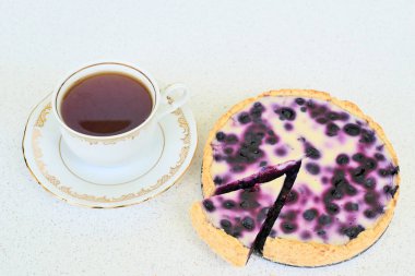 Böğürtlenli turta, fincan çay ve beyaz bir arka planda - yaban mersini yığını kapat