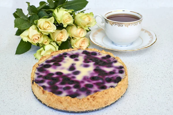 Tarta de arándanos, taza de té y rosas blancas sobre un fondo blanco — Foto de Stock