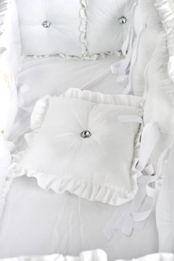 Beyaz ve yumuşak yastıkları ile Bebek karyolası/beşik