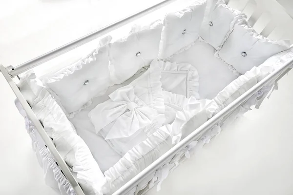Детская кроватка с белыми и мягкими подушками — стоковое фото