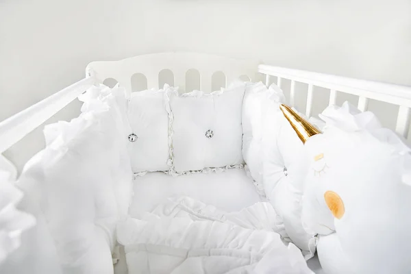 Beyaz ve yumuşak yastıkları ile Bebek karyolası/beşik — Stok fotoğraf