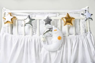 Gümüş, altın ve beyaz yıldız şeklinde yastık ve uyku ay yastık üzerinde beyaz Bebek karyolası