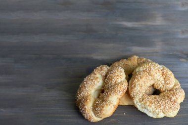 Üç adet lezzetli ve tatlı susam ahşap arka plan ile sepet kamışı pasta örgülü