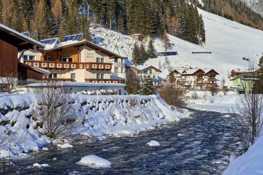 Ischgl, Avusturya - 29 Aralık 2017: Küçük dağ dere Tyrol Alpleri'nde. Ahşap evim dağ nehir tarafından kar kaplıdır.