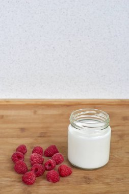 Cam Kavanoz ve ahududu ahşap bir zemin üzerine yoğurt