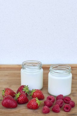 Yoğurt, ahududu ve çilek ile iki cam kavanoz