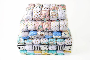 patchwork ve moda kavramı - güzel renkli yorgan, yatak örtüleri Muhafazası, beyaz zemin üzerine dikişli ürünlerin satışı için yükseklik içinde birkaç satır içinde yığılmış yığını