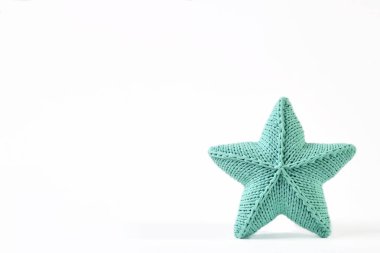 Yastık beyaz zemin üzerine mavi-yeşil örme beş köşeli yıldız şeklinde