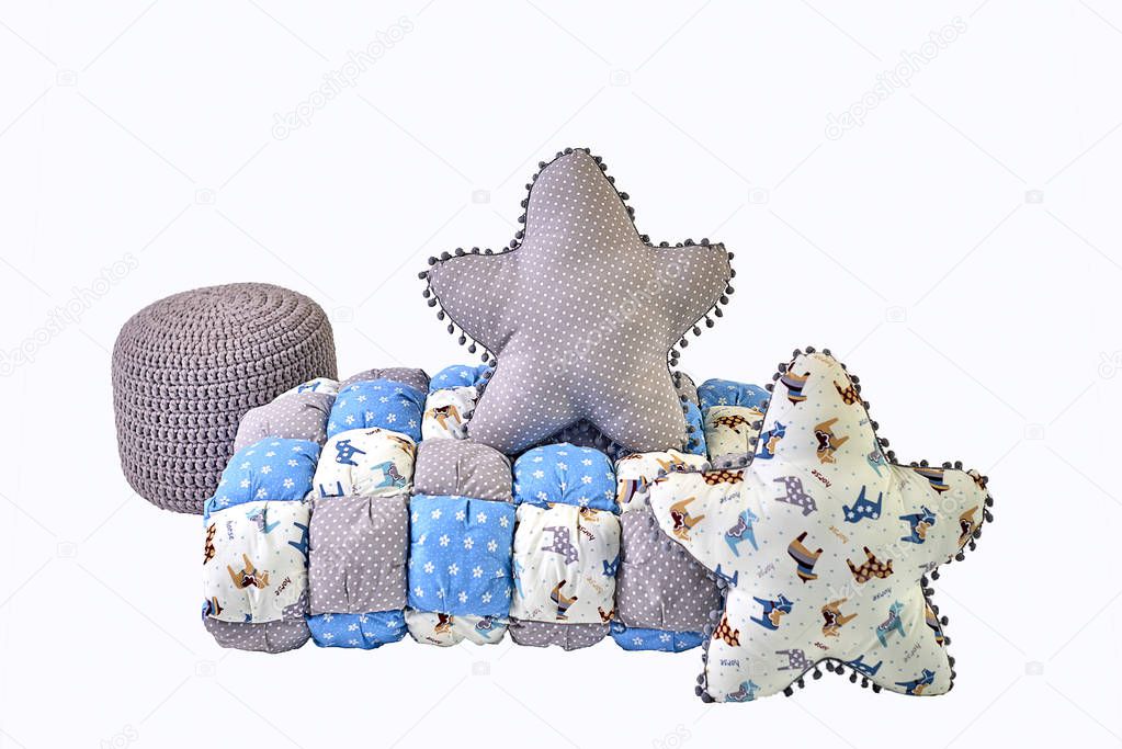 Two five-pointed star shaped pillows, patchwork comforter and knitted padded stool on white background
