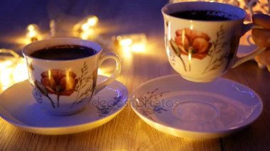 Cinemagraph - bir fincan sıcak kahve ışıklar bir arka plan üzerinde tutan el