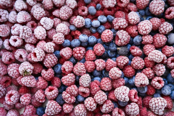 Background of frozen berries. Top view of raspberries and blueberries.