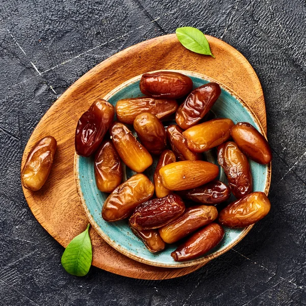 Dried dates fruits on plate. Top view of pitted dates.