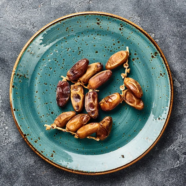 Dried dates fruits on plate. Top view of pitted dates.
