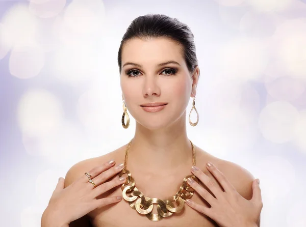 Beautiful woman in golden jewelry — Stock Photo, Image