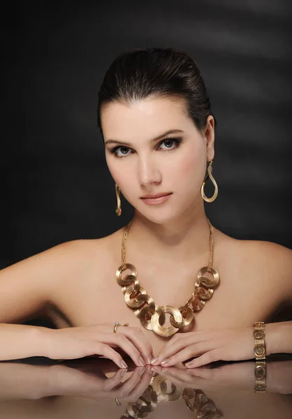 Piękna kobieta w złotej biżuterii — Zdjęcie stockowe