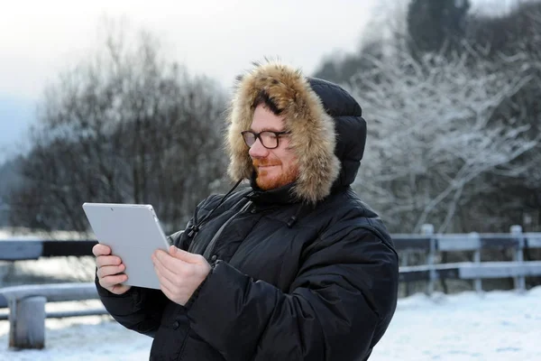 Hombre con la tableta en el parque de invierno —  Fotos de Stock