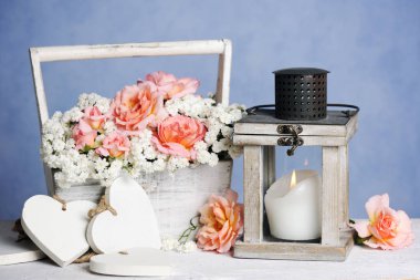 Gül ve fener mum üzerinde mavi arka plan ile oluşan