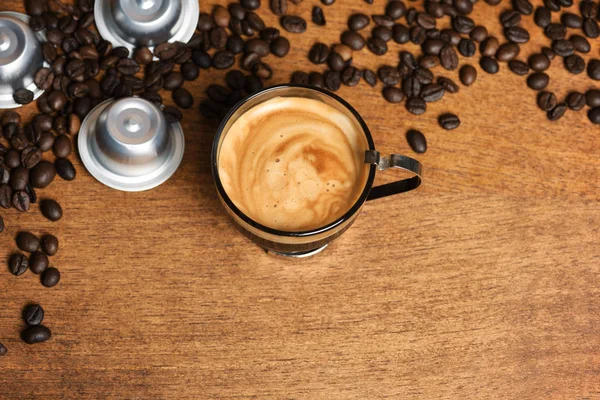 Cup of coffee with capsules and coffee beans — Stock Photo, Image