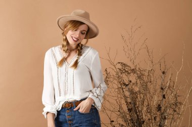 Stüdyoda kurutulmuş buketle boho tarzı kıyafetler içinde poz veren güzel kız.