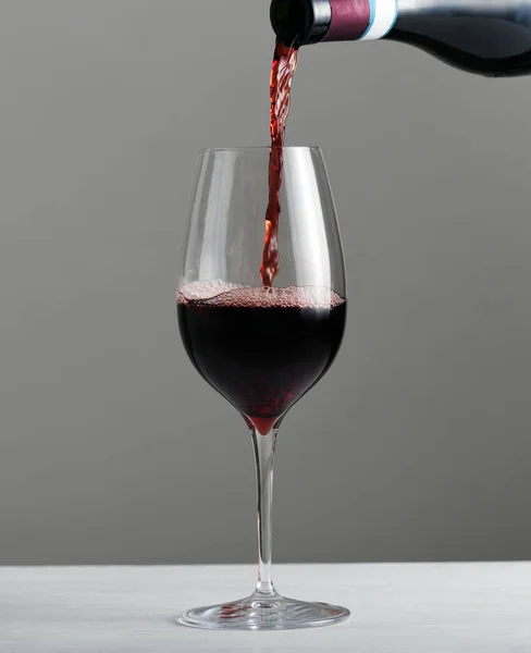 把红酒从瓶子里倒入杯子里 — 图库照片