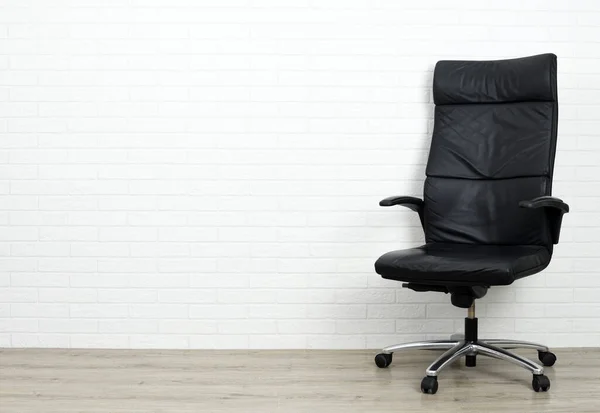 Office armchair on white brick background